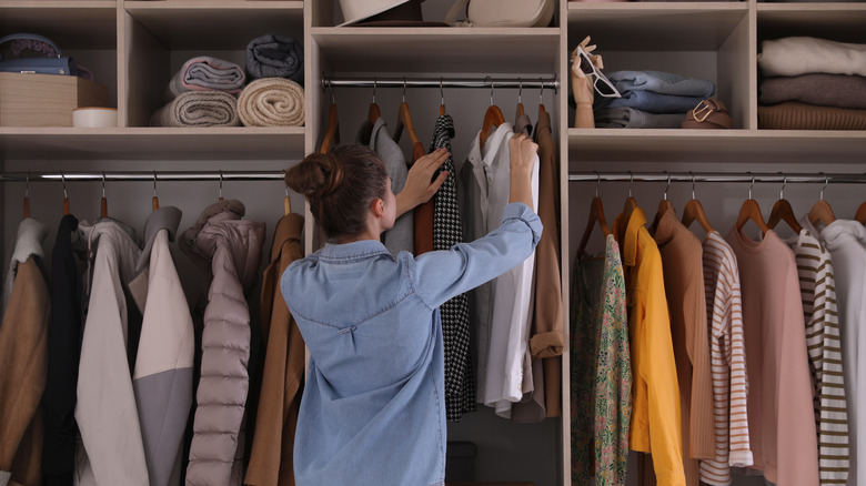 Woman stands in front of an organized closet