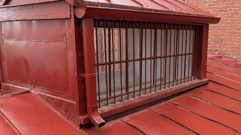 A house with roof, siding, downspout, gutters, and trim all painted maroon.