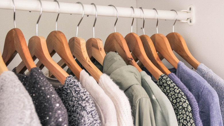 Clothes on wooden hangers in a closet
