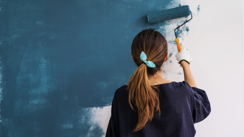 Woman painting wall blue