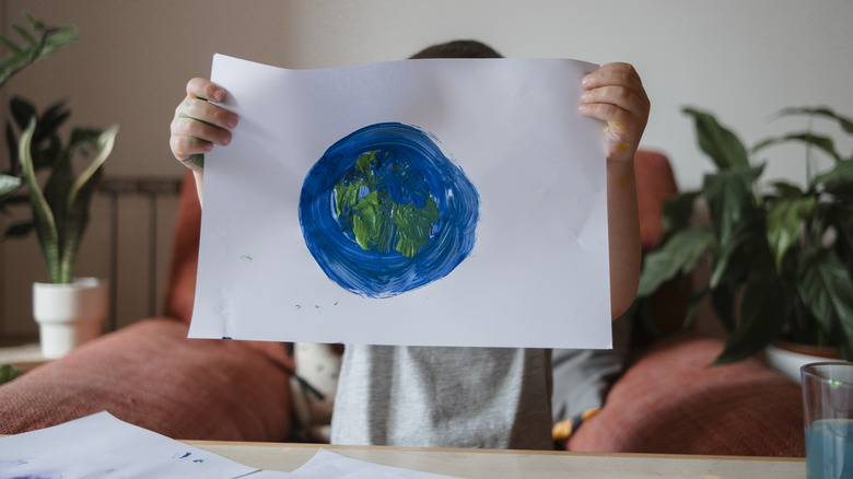 A person holding up a child's art