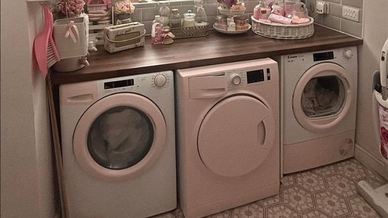 white and pink painted washer and dryers in laundry room