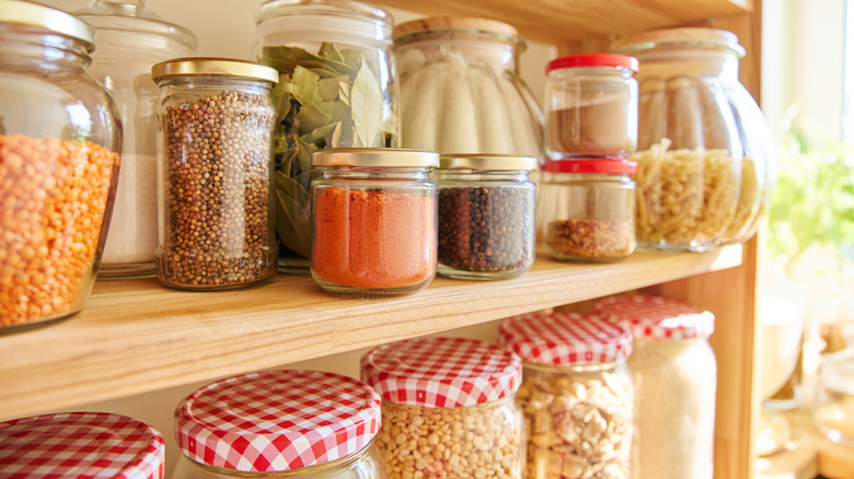 Jars of dried staples in jars on pantry shelf