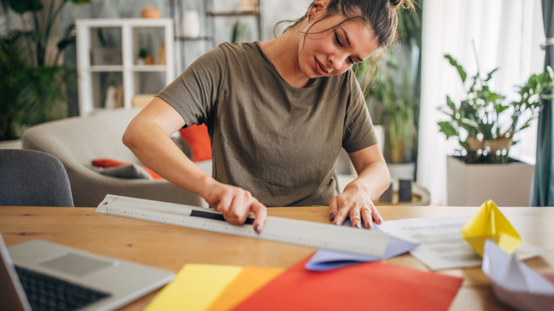Woman cutting paper with a ruler