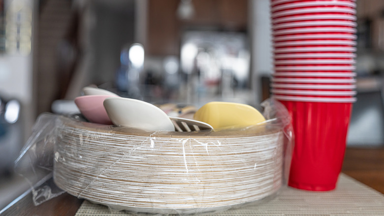 stack of paper plates and red plastic cups on counter