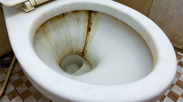 A toilet bowl with hard water stains