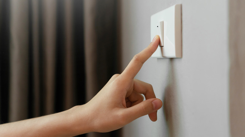 finger pressing light switch