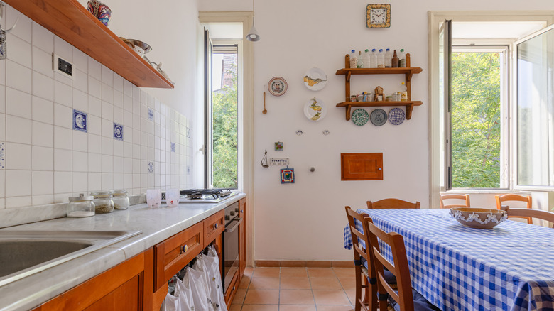 A vintage-inspired kitchen with wooden cabinets and a gingham table cloth