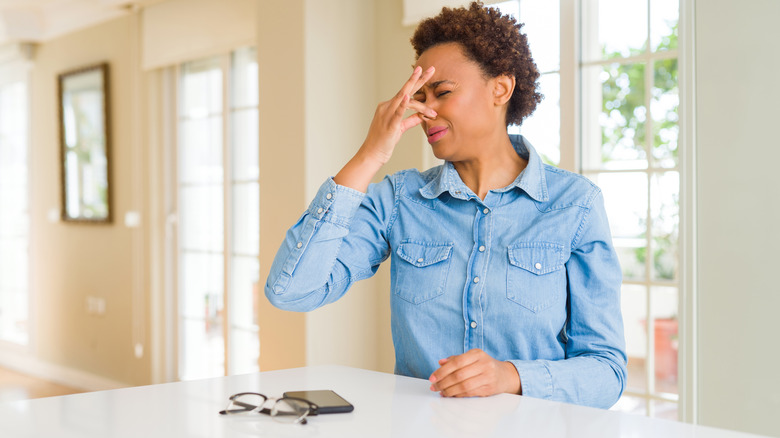 woman smelling something bad