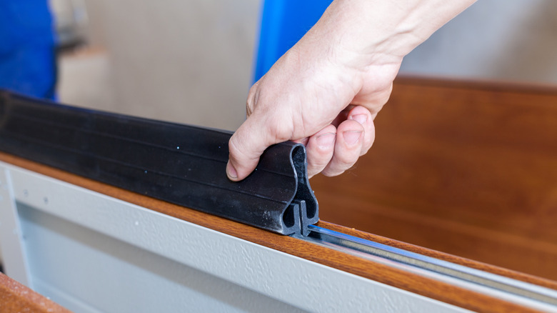 person installing new garage door seal