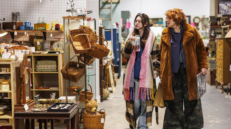 Two women looking at baskets in a thrift store.