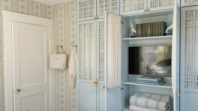 A blue built-in made of BILLY bookcases that includes a television