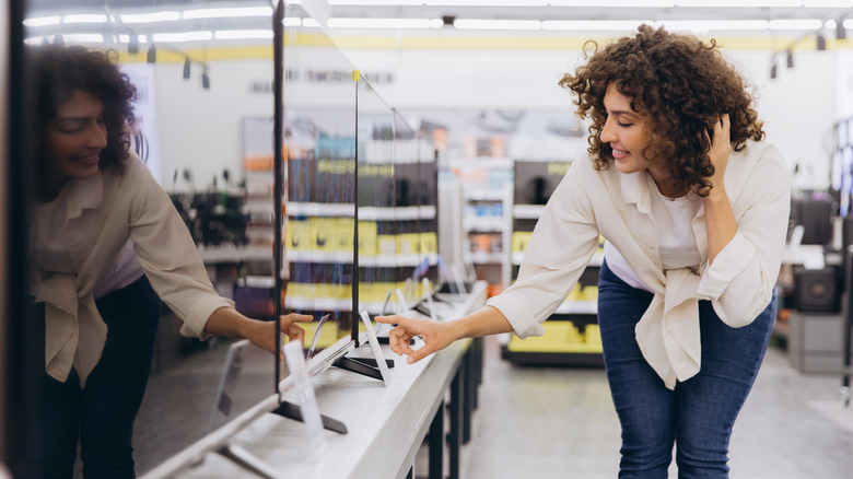 A woman shopping for a TV