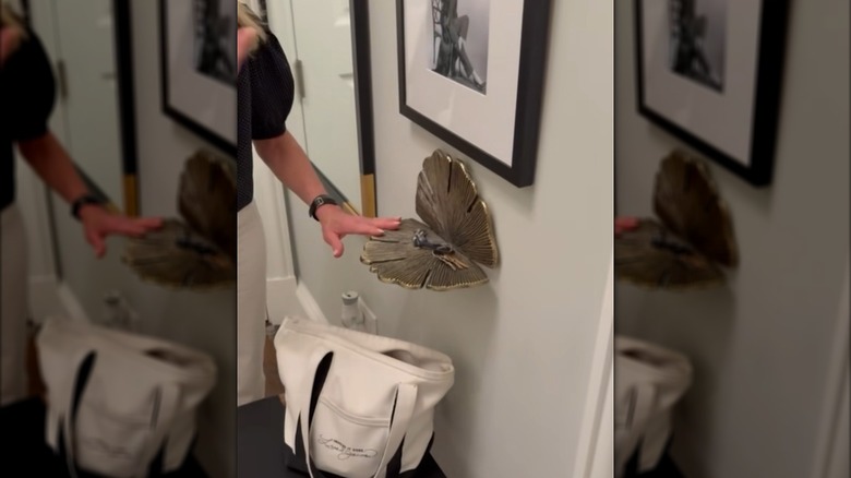 A metal shelf shaped like a gingko leaf holds keys in an entryway.