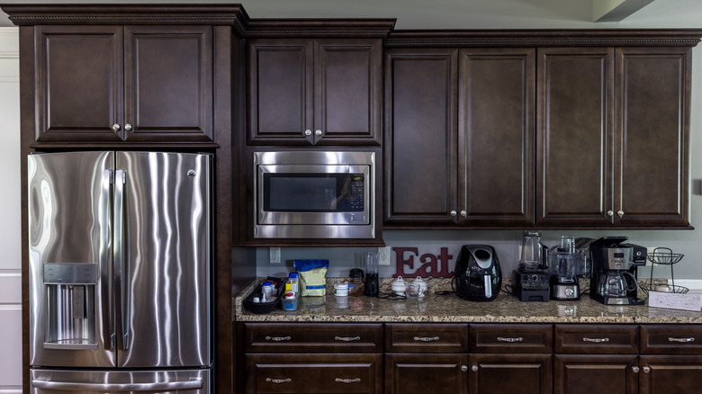 Kitchen with stainless steal appliances and dark wooden cabinets