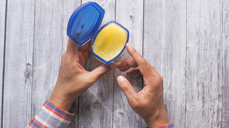 hands holding petroleum jelly