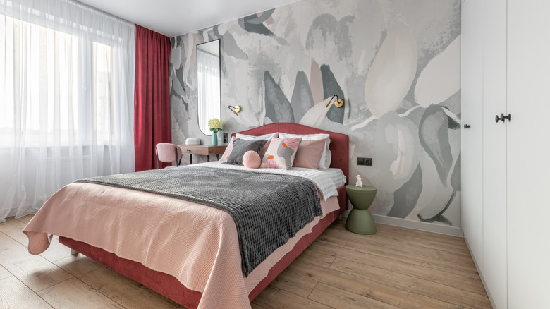 A pink and gray themed bedroom with a decorative gray wall.