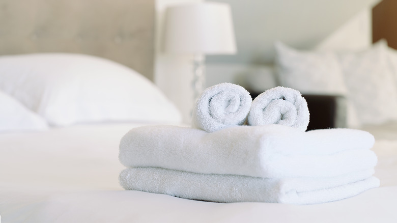 Folded white towels on bed