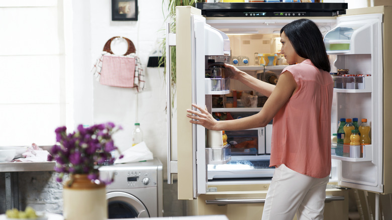 woman looking through fridge