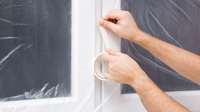 plastic wrap being taped to window