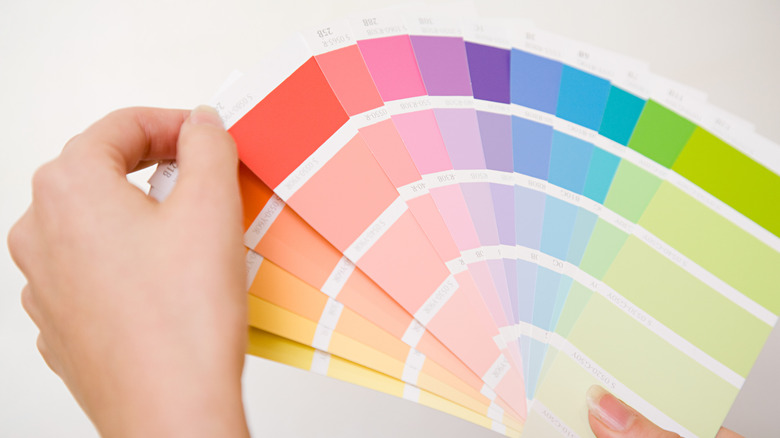 Person holding up a handful of colorful paint swatches
