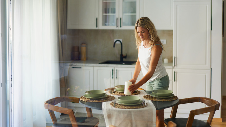 Woman setting a kitchen table at home