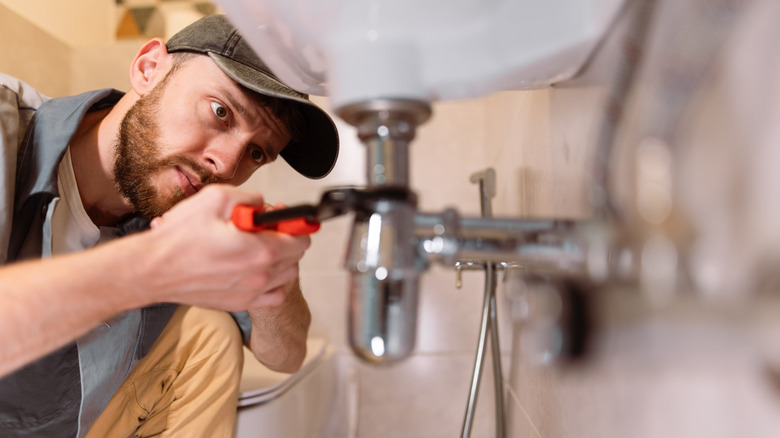 A plumber working on a sink