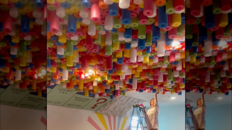 person gluing foam to ceiling