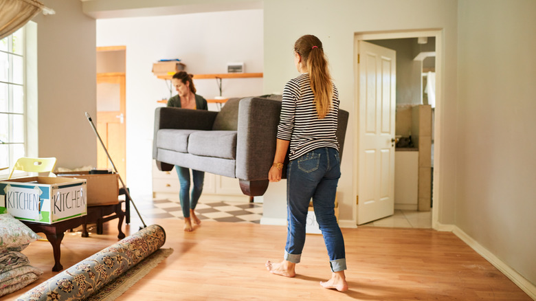 Two women moving a couch