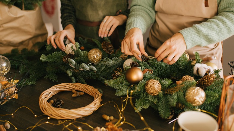hands decorating holiday greenery