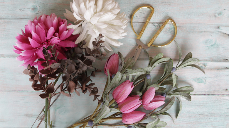 Faux flowers and scissors on table