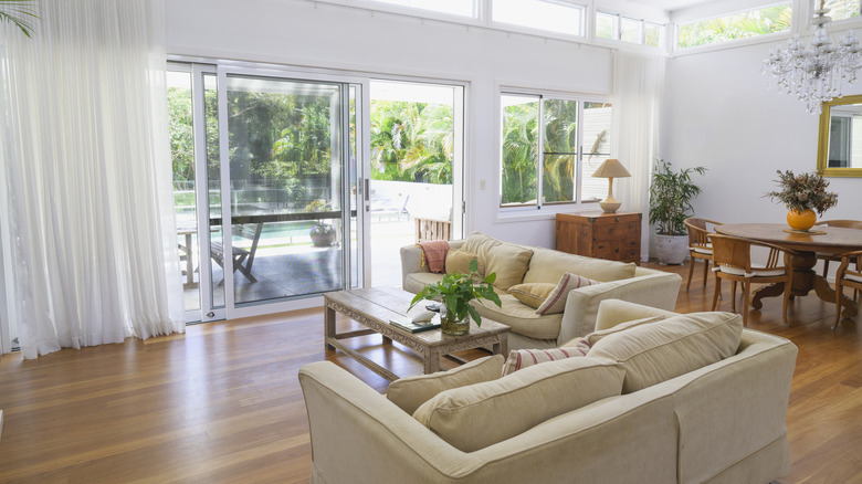 A living room with neutral furniture and hardwood floors