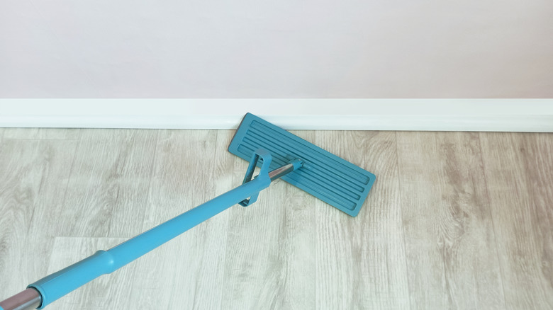 Using a mop with a flat mop head to clean baseboards