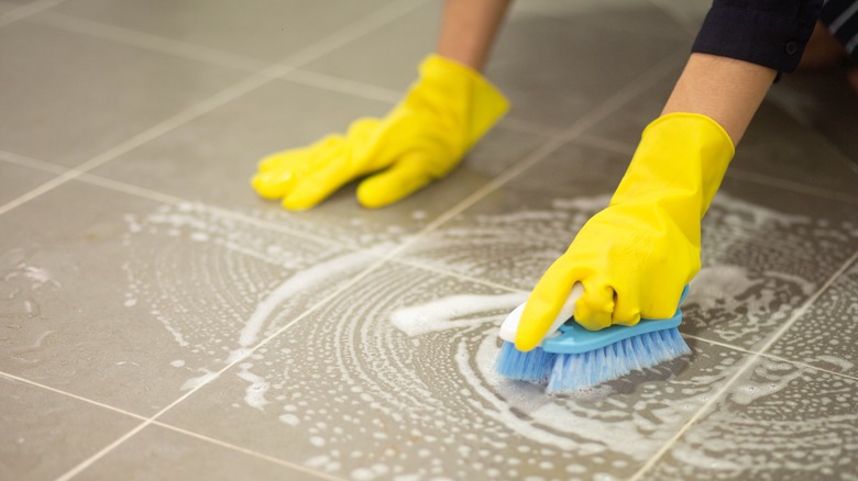 Woman scrubbing tile floor