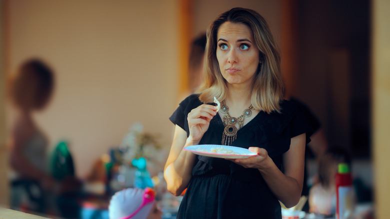 Woman standing awkwardly at party