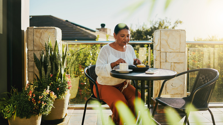 woman eating on stone patio