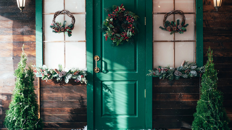 Front door of a home decorated with Christmas greenery