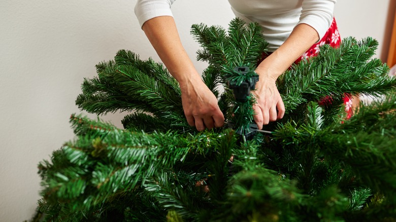 woman assembling a christmas tree