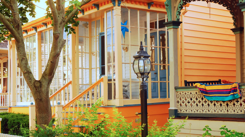 An orange house with an enclosed front porch