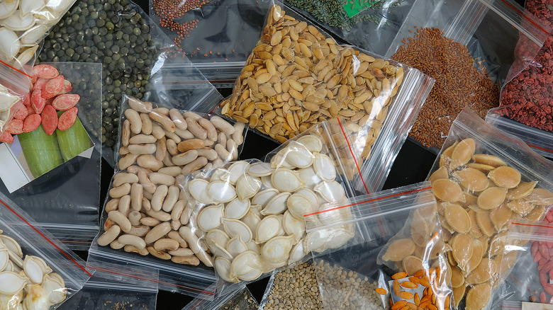 Various clear packets of seeds in an overlapping pile