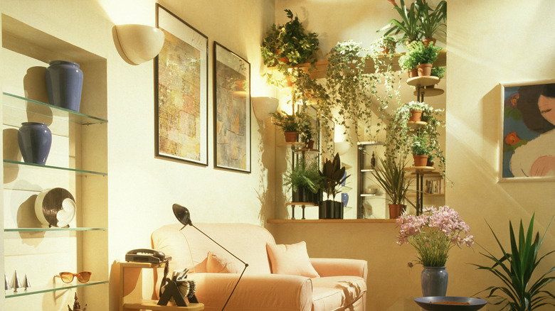 A 1980s living room decorated with plants, paintings, and sculpures.