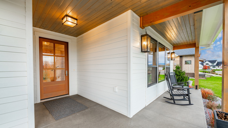 A variety of hardwired lights illuminate a simple front porch
