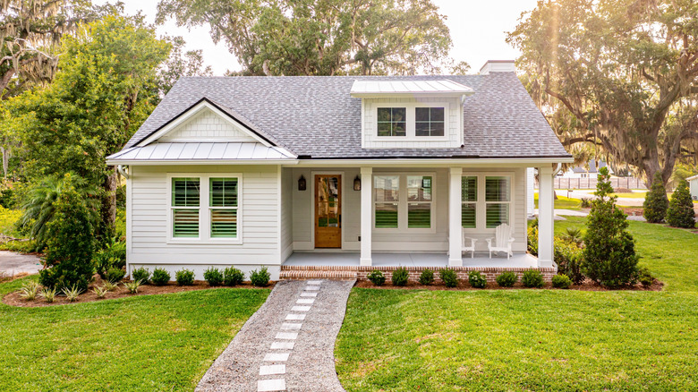 A neat footpath leads to the front porch of a small white house