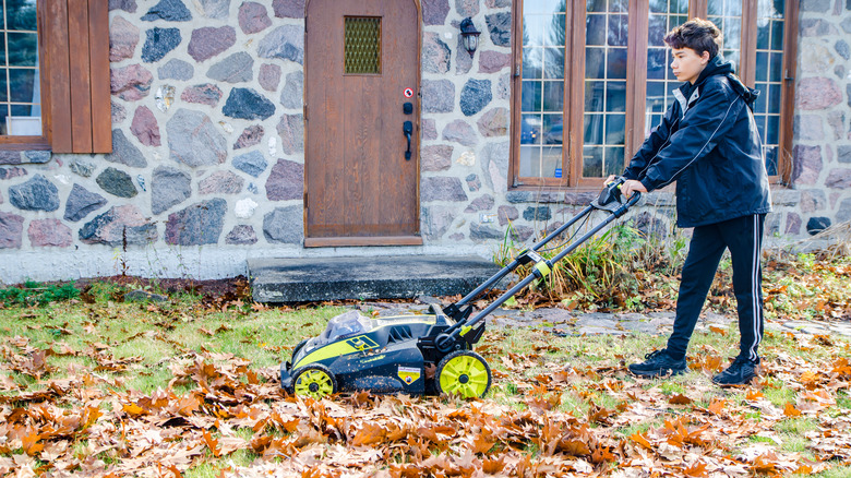 boy mowing leaves