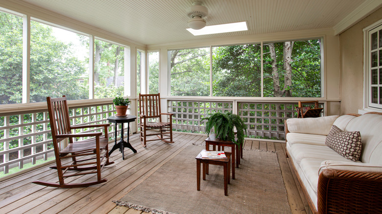 a shady porch with furnishings and a few plants