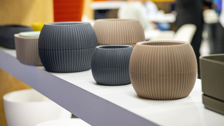 handmade clay pots displayed on a white shelf