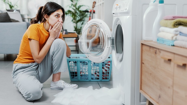 Woman overflowing the washing machine 