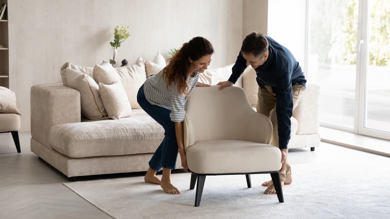 couple placing chair in room