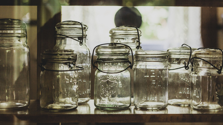 a collection of clear vintage mason jars, including several with wire closures