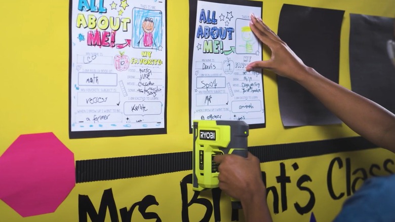 Woman stapling paper on a bulletin board